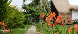 龙目岛库塔Mengalung Bungalow的鲜花屋前的小径
