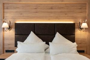马克特谢伦贝格朗普乐恒小木屋的床上有2个白色枕头,上面有2盏灯