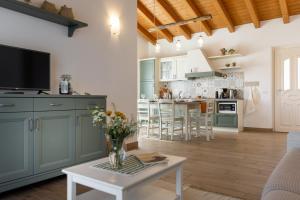 特雷莫西内Mos Country House的厨房以及带绿色橱柜和桌子的客厅。