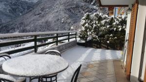 莫尔韦诺Pra de Dort Casa Vacanze的雪覆盖的山地阳台上的桌椅