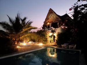 瓦塔穆HUHURU House的夜晚在房子前面的游泳池