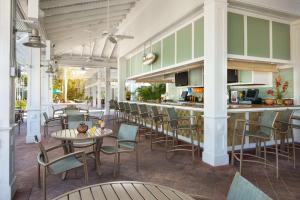 埃斯特罗Hyatt Vacation Club at Coconut Cove的餐厅设有酒吧,配有桌椅