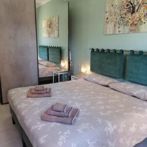 韦尔巴尼亚La perla del lago的一间卧室配有一张床,上面有两条毛巾