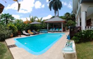 安塞罗亚莱Royal Bay Villa and Apartment的一座房子后院的游泳池