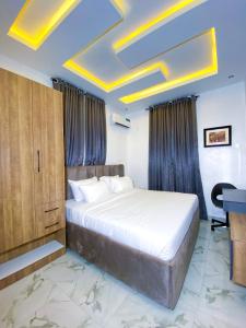 阿布贾Omah Apartments的一间卧室配有一张床和一张书桌