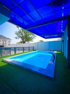 阿布贾Omah Apartments的蓝色天花板下的大型游泳池