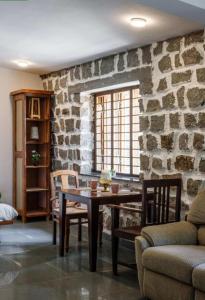 SanivÄrsanteJungle stay by Bilwa Estate的一间设有桌子和石墙的用餐室