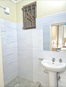 基苏木3 BDR Luxurious Villa in Milimani Kisumu的白色的浴室设有水槽和窗户。