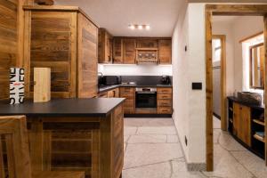 摩德纳迪-坎皮格里奥Maroc Mountain Chalet的厨房配有木制橱柜和黑色台面
