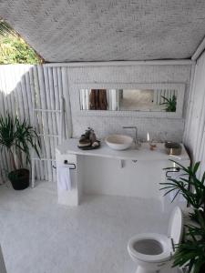 珀尼达岛Tropical Glamping Nusa Penida - Private Romantic Seaside Bungalow Diamond Beach的白色的浴室设有水槽和卫生间。