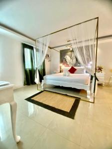 安吉利斯Hotel Euroasia By BLUEBOOKERS的卧室配有带窗帘的大型白色床