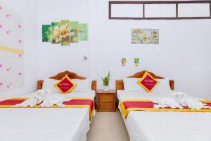 头顿Villa Hồ Bơi HOÀNG ĐỨC Trung Tâm BÃI SAU的白色墙壁客房的两张床