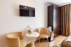 伊斯坦布尔库姆酒店的一间设有两把椅子、一张桌子和一台电视的房间