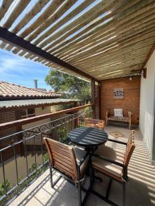 布希奥斯Pousada Villa Canaã的阳台的天井配有桌椅