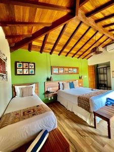 布希奥斯Pousada Villa Canaã的配有绿色墙壁和木地板的客房内的两张床