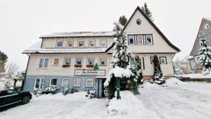 布劳恩拉格Hotel garni Am Hochwald的一座雪覆盖的房子,前面有一个停车计