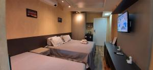 维多利亚Apartamento Mania Terceiro Andar的小房间设有两张床和电视