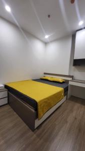 河内Meii House - Vinhome Ocean Park S201的卧室里设有一张黄色的床