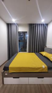 河内Meii House - Vinhome Ocean Park S201的一间卧室配有一张黄色毯子床