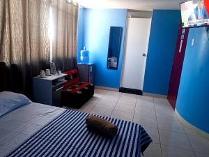 齐克拉约CASA COMPARTIDA的一间带蓝色墙壁、一张床和电视的卧室