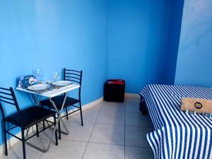 齐克拉约CASA COMPARTIDA的蓝色的客房配有桌椅和一张床