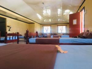 Naviti IslandKorovou Eco Lodge的带三张床和两扇窗户的房间