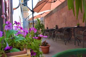 埃里温埃里温米亚卡萨酒店的一个带桌椅和紫色鲜花的庭院