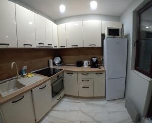 鲁塞Витски的厨房配有白色橱柜和白色冰箱。