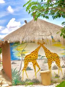 尼亚加托尔比酒店的两个长颈鹿站在草棚下
