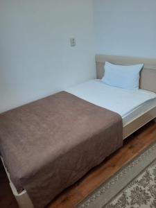 塔尔迪库尔干Апарт отель Welcome的一张带白色床单和枕头的床