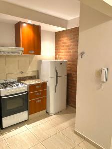 圣罗莎Complejo Pampa 1的厨房配有白色冰箱和炉灶。