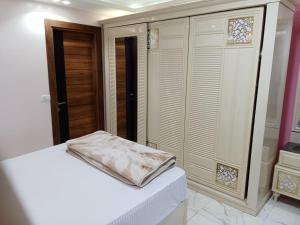 开罗Cairo Giza cozy modern luxury apartment near the Nile and museum شقة مودرن المهندسين的卧室配有白色的床和衣柜。