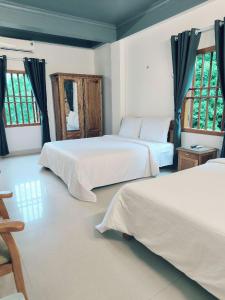 吉婆岛Cat Ba Central的一间卧室设有两张床和两个窗户。