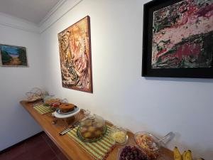帕拉蒂Casa Arte Cabore的墙上挂着画作的桌子上放着食物