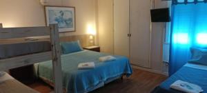 马德普拉塔Hotel PerlaMar的一间卧室配有两张双层床,铺有蓝色床单。