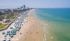 头顿The Song VT Beach Apartment的海滩上的人与遮阳伞景