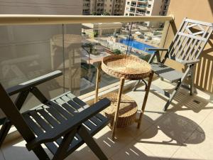 迪拜Nice Location - 76 m2的阳台配有蓝色长椅和桌椅。