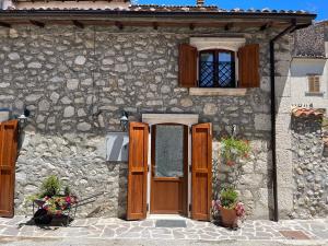罗卡迪梅佐Baita delle Rocche的石屋,设有木门和窗户