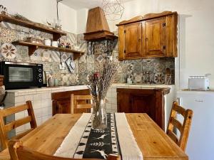 罗卡迪梅佐Baita delle Rocche的厨房配有木桌和花瓶