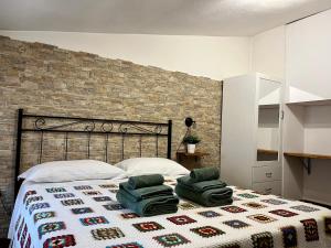 罗卡迪梅佐Baita delle Rocche的一间卧室配有一张床,上面有两条毛巾