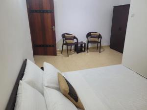 斯里贾亚瓦德纳普拉科特M-stay Colombo的一间卧室配有一张带两把椅子和镜子的床
