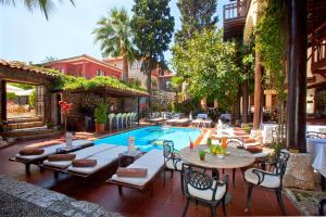 安塔利亚Alp Pasa Hotel - Special Class的一个带游泳池和桌椅的庭院