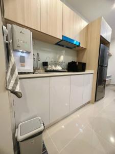哥打京那巴鲁Sunset Seaview Studio Apartment at Kota Kinabalu City Centre的厨房配有白色橱柜和炉灶烤箱。