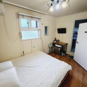 首尔Joy Guesthouse的卧室配有白色的床和窗户。