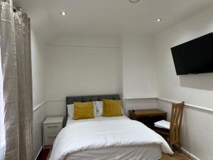 布罗姆利Double Room With Free WiFi Keedonwood Road的一间卧室配有一张床和一台平面电视