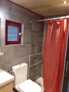 Ménétrux-en-JouxLa p'tite maison bois du hérisson的浴室设有卫生间和红色的淋浴帘
