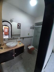 卡波布里奥Pousada Chez Moi的一间带水槽、卫生间和镜子的浴室