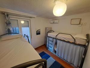 格拉纳达Hostel El Cascabel的客房设有两张床和窗户。