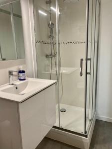 Vert-le-GrandWelcome Home的带淋浴和盥洗盆的白色浴室