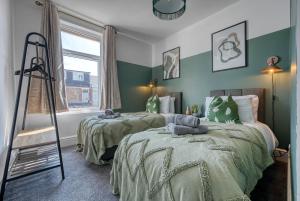 朴次茅斯Modern Townhouse 3-BR, Sleeps 8, Central Location by Blue Puffin Stays的两张床位于带绿色和白色墙壁的客房